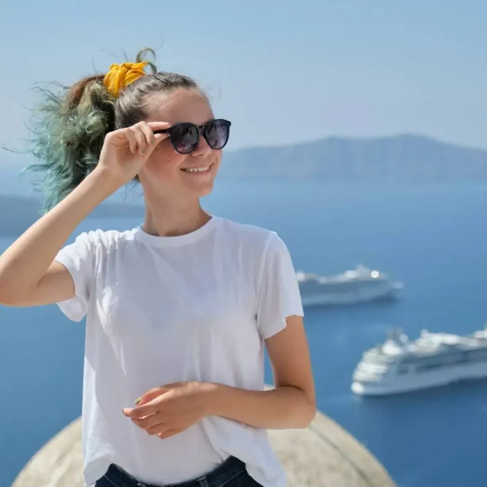 Young girl tourist smiling, background scenic sea landscape with cruise liners